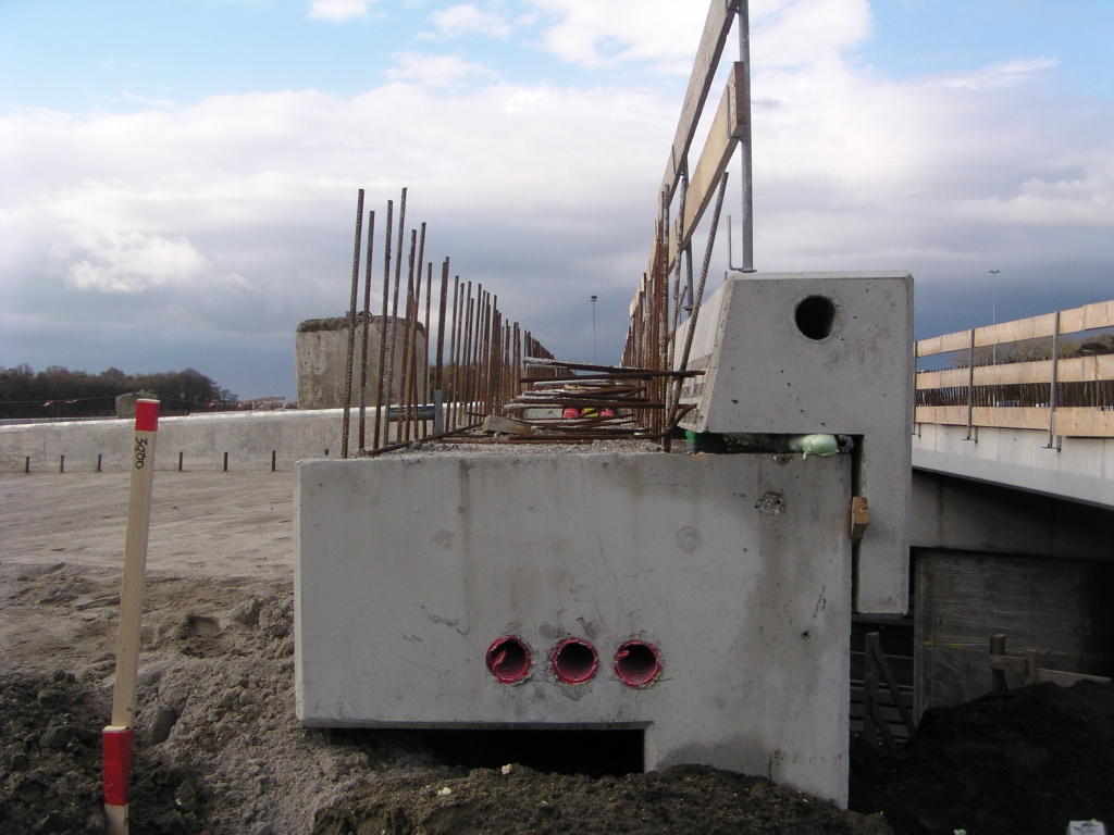 p4050036.jpg - Met de lekenblik lijkt het erop dat de betonnen zijschotjes met schuim en blokjes hout en plastic worden gesteld, en daarna in een betonlaag verankerd.