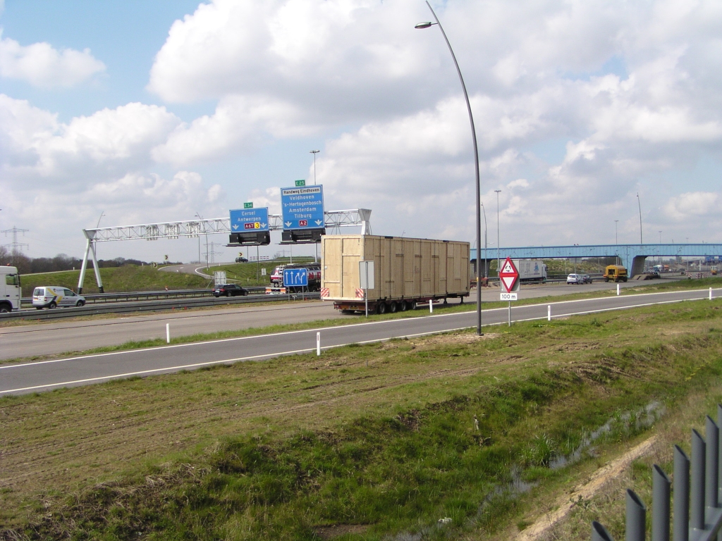 p4170044.jpg - Op de parallelbaan bij de high tech campus staat deze trailer van de firma Mammoet, met geheel houten "container" erop.