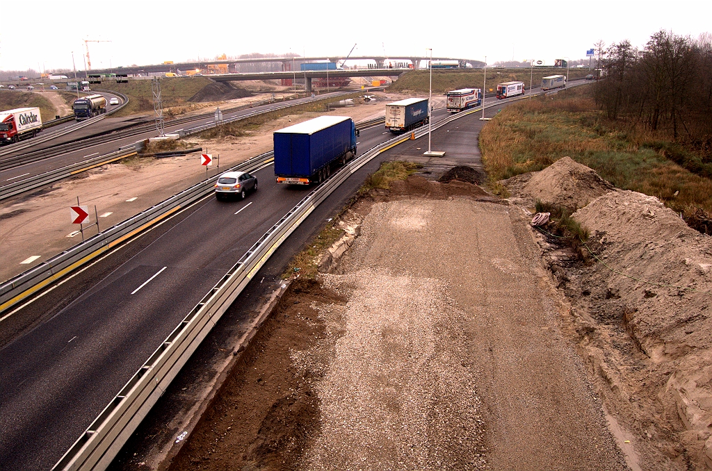 20081212-134720.jpg - In oostelijke richting sluit de beginnende puinfundering aan op een reeds eerder aangelegde strook asfalt. Die werd alvast neergelegd bij de aanleg van de tijdelijke A67-zuid bypass langs kp. de Hogt, zo'n 2 jaar geleden. Daarna loopt het vooralsnog dood op het dijklichaam van de A2 hoofdrijbaan.  week 200843 