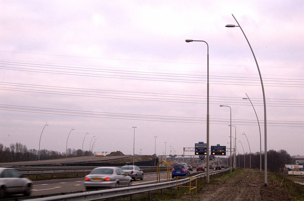 20081225-145837.jpg - Ook lichtmasten (ongefundeerd) geplaatst aan de overzijde, langs de A2 in de richting 's Hertogenbosch. Op het verbrede talud staan de nieuwe masten zo ongeveer een rijstrookbreedte verder van de rijbaan dan de oude. Daar zou dan de vluchtstrook komen te liggen van het naar vier rijstroken te verbreden wegvak.  week 200825 