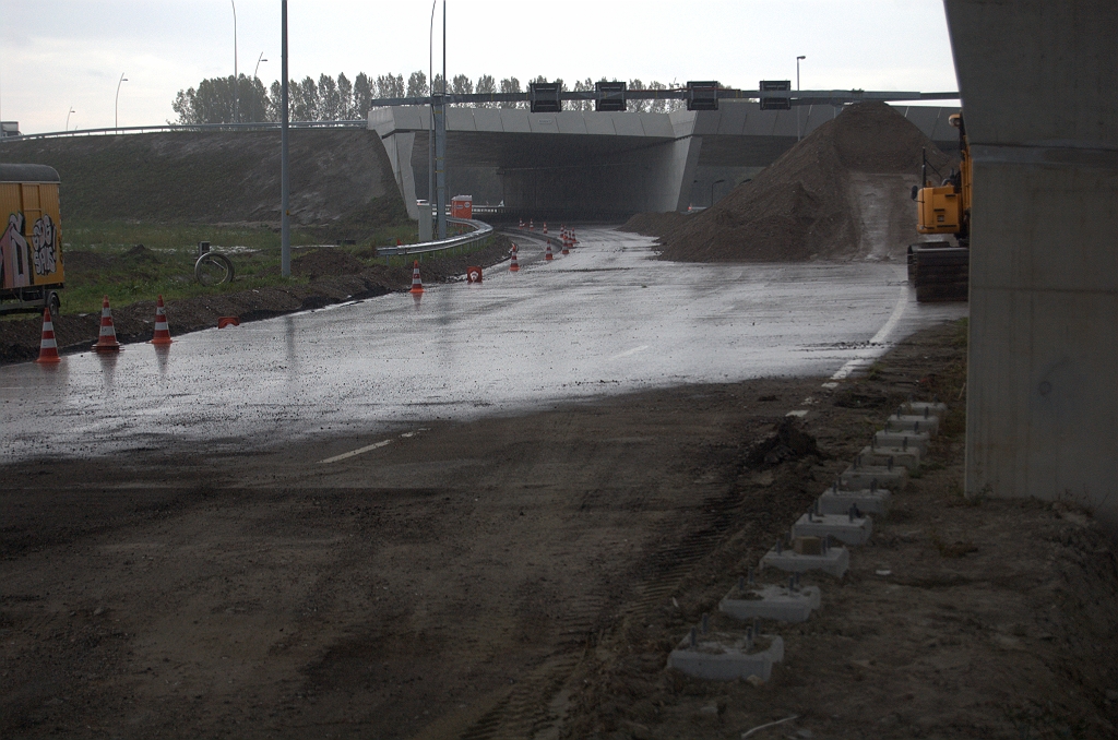 20091011-171644.bmp - Door het verwijderen van barriers worden geleiderailfunderingen zichtbaar ter botsbeveiliging van een steun onder KW 4C, zo ongeveer op de grens van te handhaven asfalt in de A2 hoofdrijbaan in de richting Maastricht. Verderop bij KW 5 is nog net te zien dat er een strook asfalt is verwijderd voor het op breedte brengen van de definitieve rijbaan.
