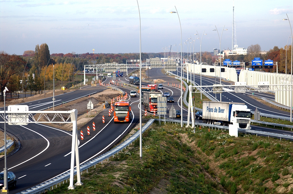 20091028-153514.bmp - Terug naar de noordzijde van KW 19. Zicht op de "Poot van Metz" helaas geblokkeerd door alle portalen. Als KW 19 wordt opengesteld zal het alleen voor personenauto's nog zijn toegestaan om het (dan enkelstrooks?) oversteekje naar de hoofdrijbaan te nemen. Bovendien is het dan (voorlopig) niet meer mogelijk de A2 in de richting Maastricht te bereiken vanaf die hoofdrijbaan. Het meeste verkeer zal dan ook over KW 19 gaan rijden.