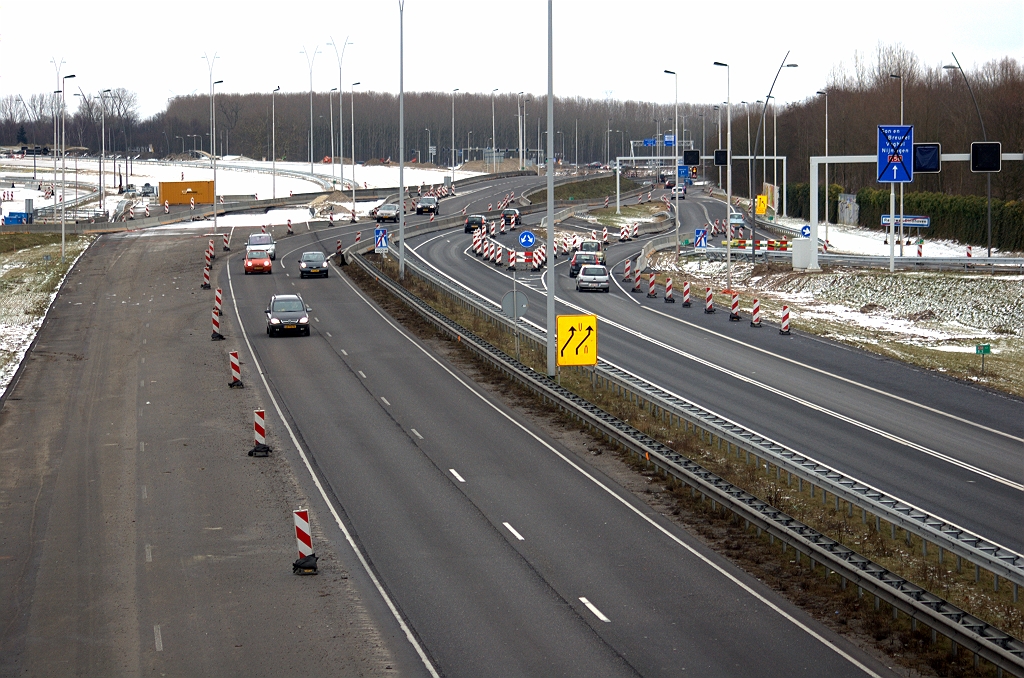 20100213-154258.bmp - Aansluiting Ekkersrijt, oostzijde. Moeilijk te zien op de foto, maar de afrit vanuit de richting Nijmegen (linksboven) is enigzins verlegd zodat hij over het nieuwe asfalt van de noordelijke A50 rijbaan loopt, zodat die kan worden aangesloten op de rijbaan linksvoor.  week 200947 