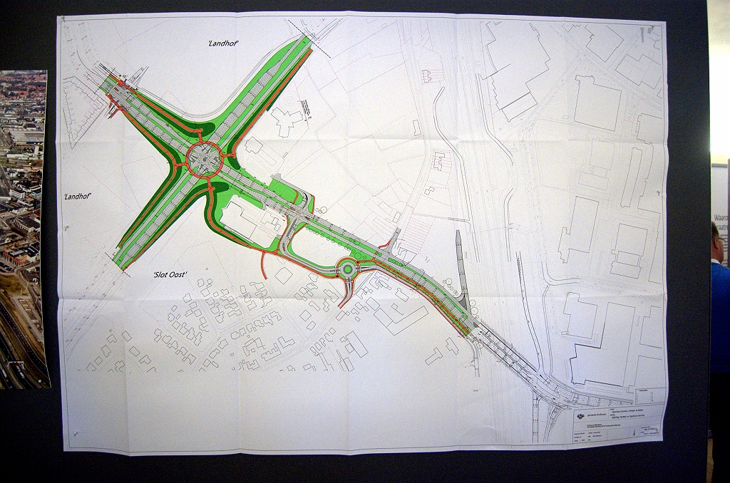 20100330-194128.bmp - Ook de gemeente Eindhoven is aanwezig met de plannen voor het onderliggend wegennet in de nabijheid van de aansluitingen Veldhoven en Meerenakkerweg. Linksboven zien we het toekomstige kruispunt Noord-Brabantlaan/Heistraat, thans een rotonde. De rode cirkel is een boven de kruising aan te leggen fietsersrotonde, hangende aan een mast die midden in het kruispunt uit de grond steekt.