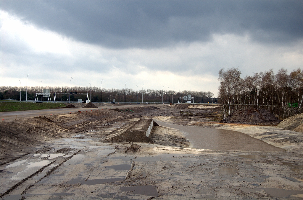 20100404-152231.bmp - Tegen de een week geleden geplaatste grondkeringen parallel aan de verbindingsweg Nijmegen-Breda is een grondlichaam aangelegd. Er lijkt ook een verband te bestaan met de eveneens nieuw aangelegde waterpartij ter rechterzijde.  week 201012 
