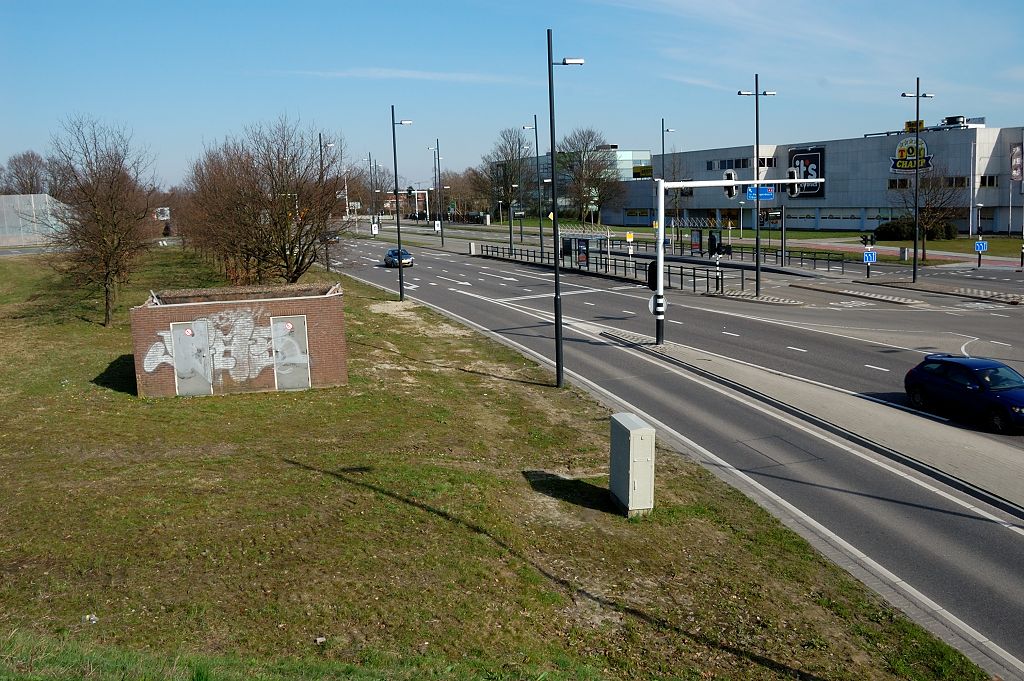 20110320-144750.JPG - Minder geslaagde foto van de oostzijde van de aansluiting. De stopstreep in de afrit vanuit de richting Maastricht is nog net zichtbaar tussen de bomenrij. Die komt dus ook te vervallen, en het verkeer zal de Noord-Brabantlaan niet meer op kunnen maar in plaats daarvan op de rijbaan uit de vorige foto terecht komen.