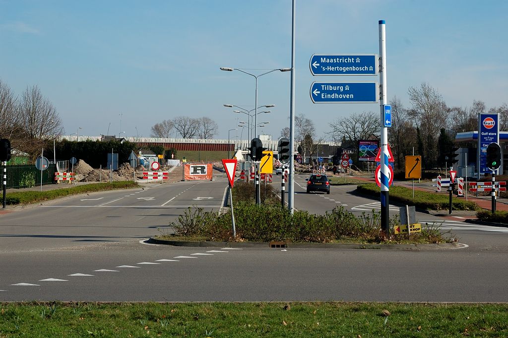 20110320-153627.JPG - Vierde rotonde-arm is de Heistraat, thans van enig belang voor de relatie naar Eindhoven, met name het bedrijventerrein de Hurk. Op de achtergrond de geluidsschermen van de N2 en A2, en het is duidelijk dat het belang van de Heistraat substantieel zal toenemen als de nieuwe aansluiting Meerenakkerweg gereed is. Vanaf de tot kruising te verbouwen rotonde heeft men dus in de toekomst de keuze uit twee volledige aansluitingen op de N2, elk op minder dan een kilometer afstand.