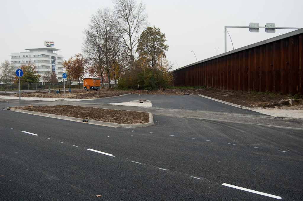 20111106-150507.jpg - Verder met het fietspad in de kruising met de afrit vanuit de richting Maastricht. Zo te zien is van het nieuwe asfalt in de rijbaan meteen weer een laagje afgefreesd, om er de rode fietspad-deklaag voor in de plaats te leggen.  week 201143 
