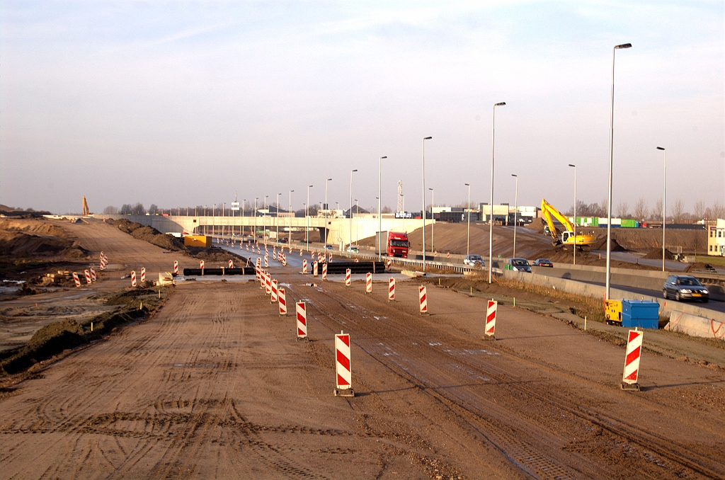 20090124-101816.jpg - De situatie op de grond. Op het talud links komt de rotonde-bypass weer samen met de toerit in de richting Oss vanaf de rotonde, om de relatie Ekkersrijt-Woensel te kunnen bedienen. In de eindsituatie splitst de verbindingsweg naar Woensel zich beneden aan het talud weer af en gaat verder over een nog niet aangelegd deel van de fietstunneloverkluizing.