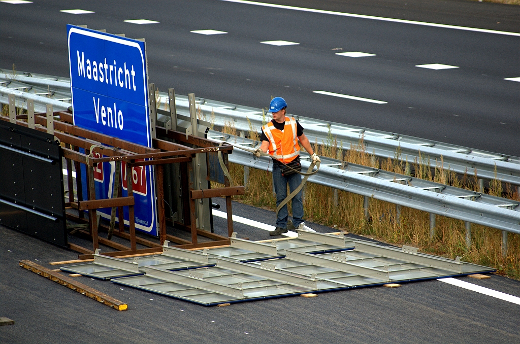 20090912-095948.bmp - Bord wat op de weg ligt moet nog in elkaar gezet. Gelukkig is het beschermd met houten plankjes. Ook de schilden voor de matrixborden moeten nog bevestigd.